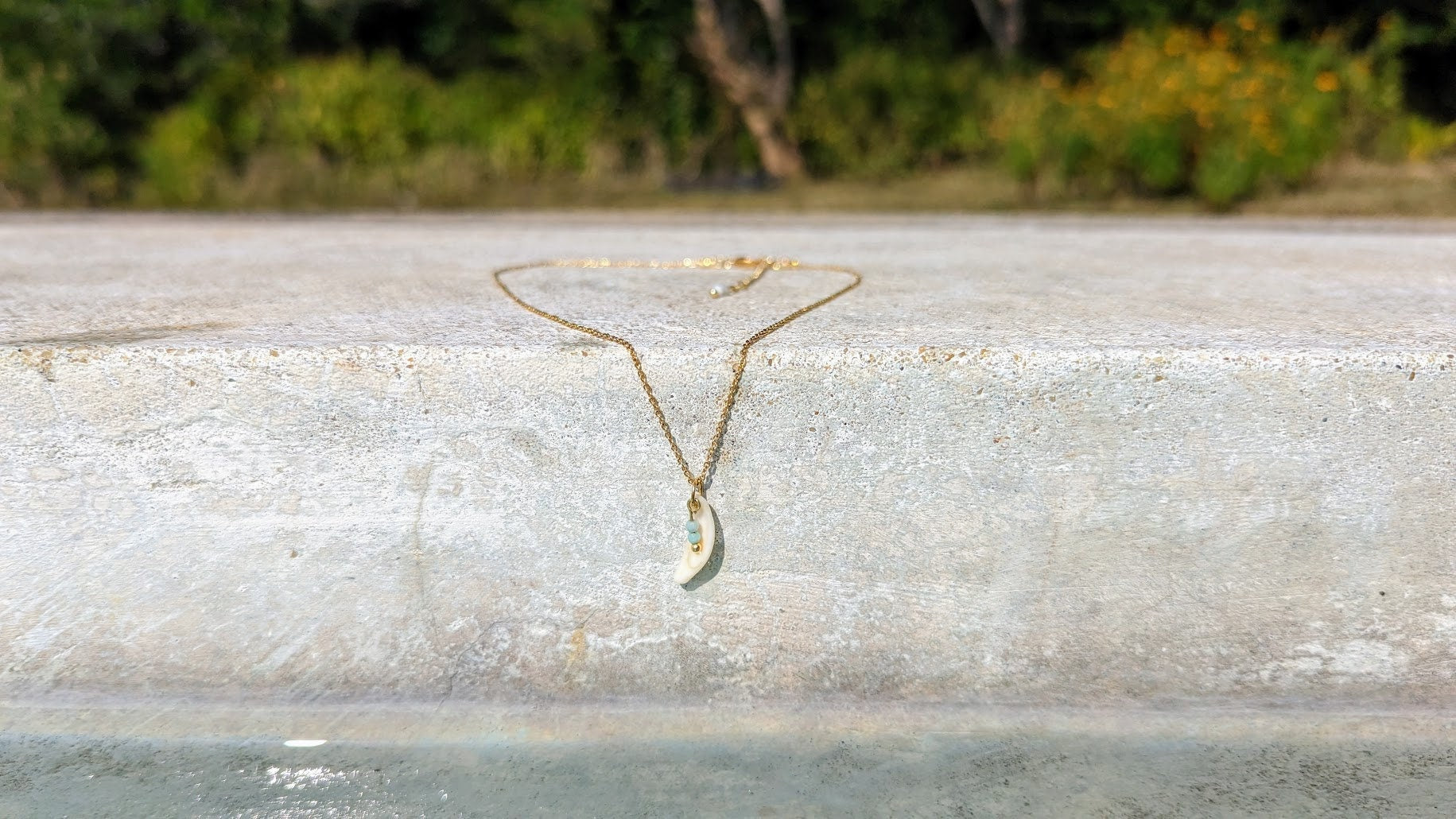 Dainty, gold stainless steel necklace with a cowrie shell pendant and tiny gemstones (personalizable and waterproof).