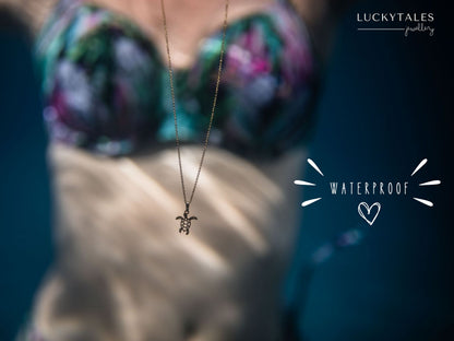 Dainty, gold stainless steel necklace with a cowrie shell pendant and tiny gemstones (personalizable and waterproof).