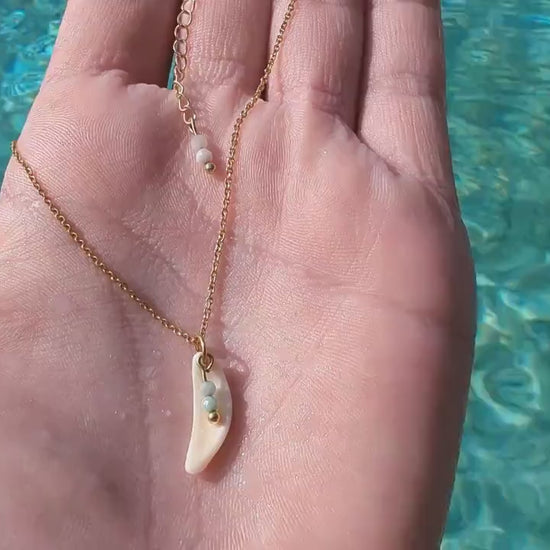 Dainty, gold stainless steel necklace with a cowrie shell pendant and tiny gemstones (personalizable and waterproof).