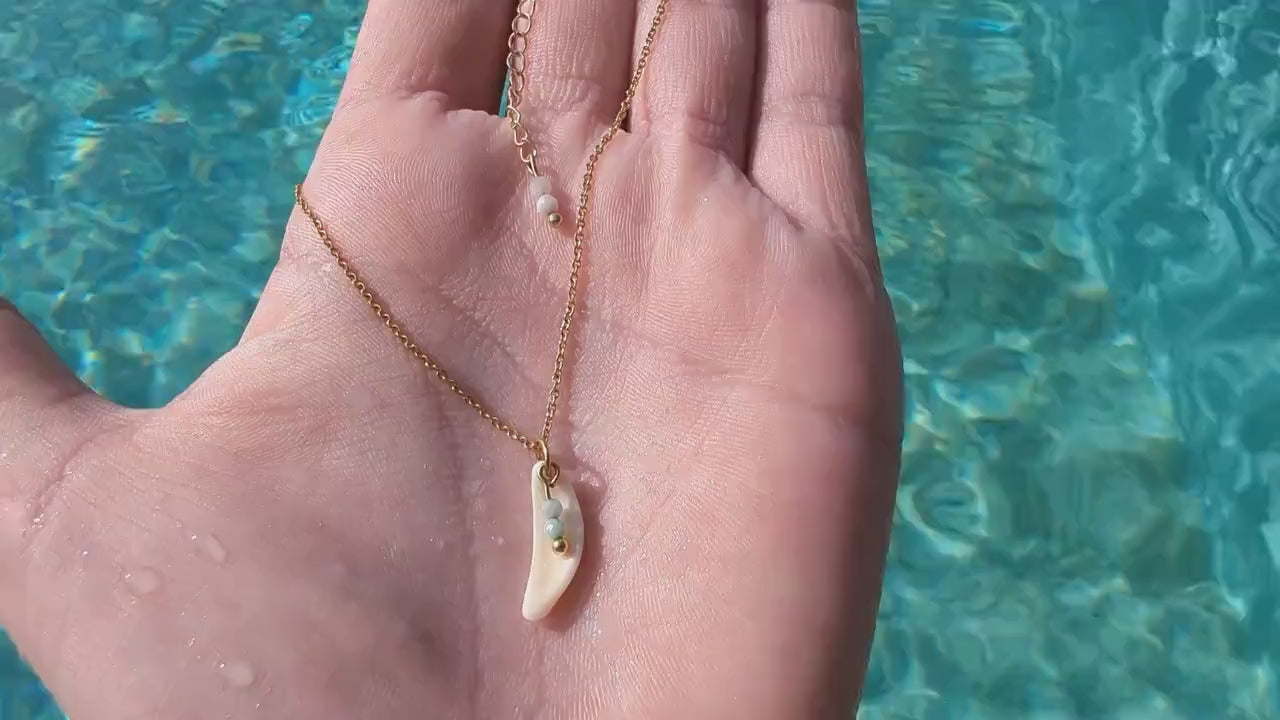Dainty, gold stainless steel necklace with a cowrie shell pendant and tiny gemstones (personalizable and waterproof).